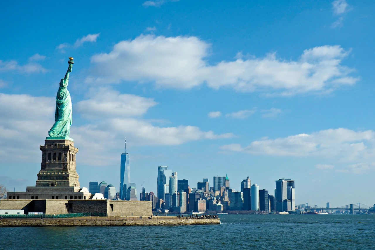Statue of Liberty and the Lower Manhattan skyline under bright blue skies